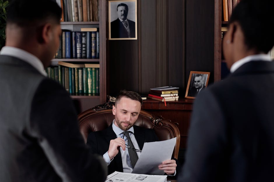 Three professionals in a classic office setting discussing legal documents.